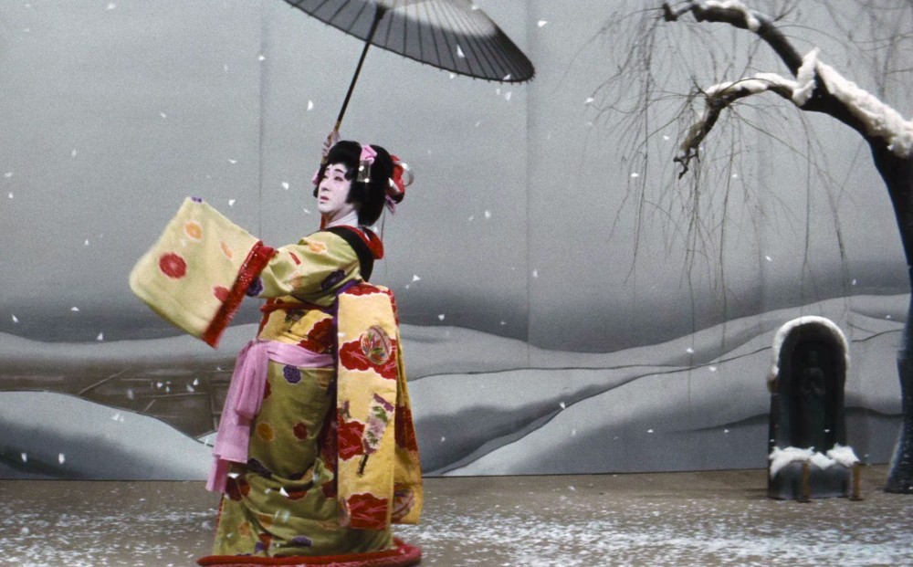 Actor Kazuo Hasegawa in onnagata (a man playing a woman in kabuki) costume on a stage with a snowy set.