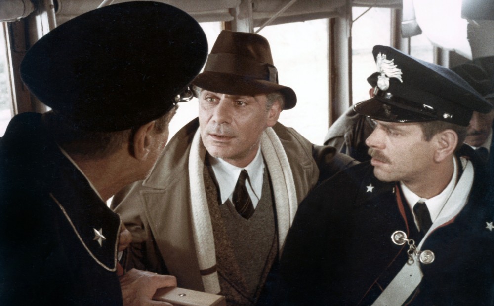 Actor Gian Maria Volontè speaks with two police officers.