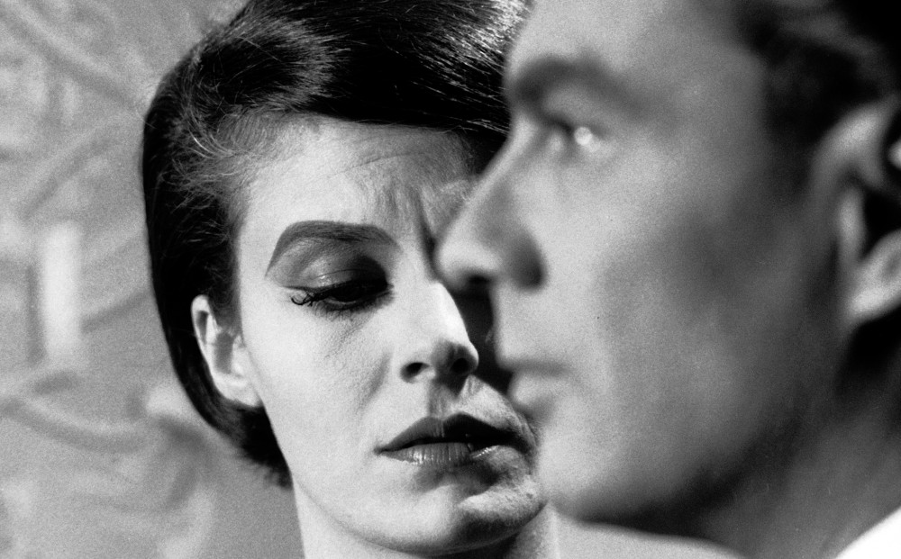 Actor Giorgio Albertazzi in profile; Delphine Seyrig looks pained behind him.