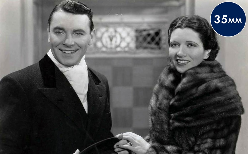 Actors George Brent and Kay Francis smile at something off-camera. 