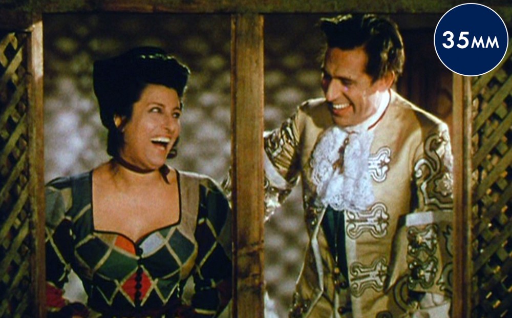 Actor Anna Magnani and a man laugh with each other.
