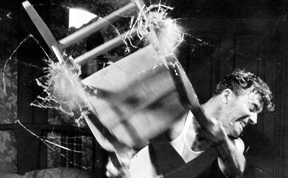 Actor Burt Lancaster smashes a chair into a mirror.
