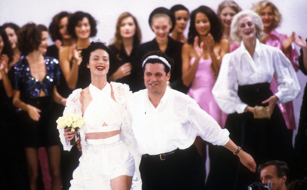 Fashion designer and subject of UNZIPPED Isaac Mizrahi on a runway, surrounded by super models.