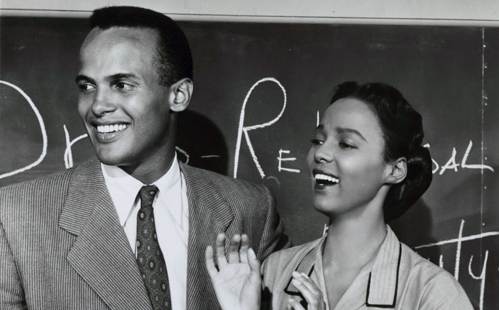 Actors Dorothy Dandridge and Harry Belafonte stand by a chalkboard.