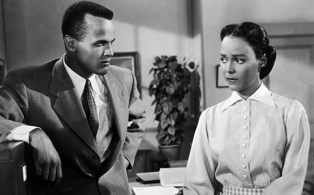 Actors Dorothy Dandridge and Harry Belafonte stand in an office.