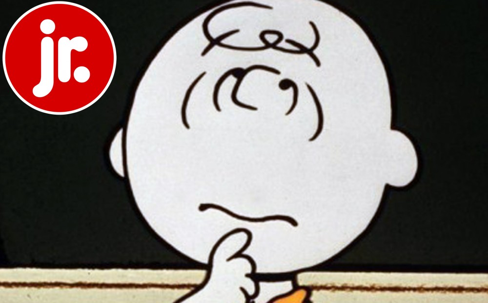 Charlie Brown looks pensive, with his hand rested on his chin.