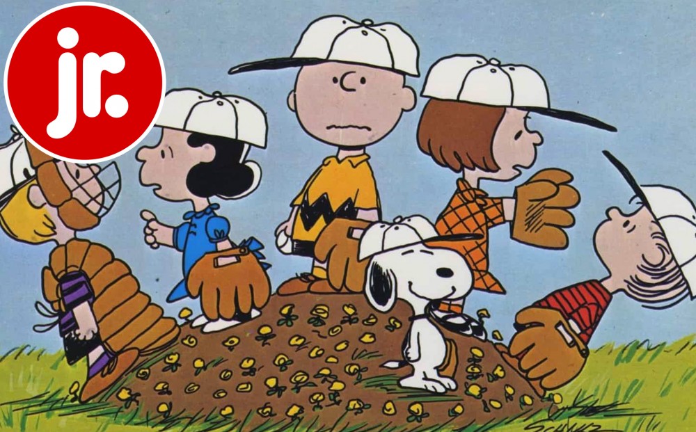 All of the Peanuts characters wear baseball gear and stand on a mound of dirt.