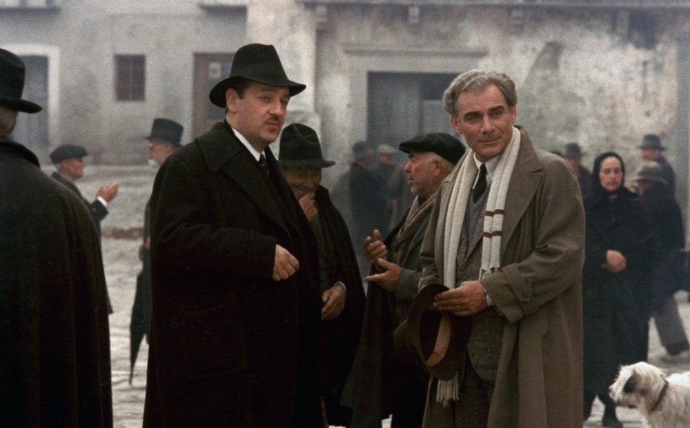 Actors Baolo Bonacelli and Gian Maria Volontè confer in a town square.