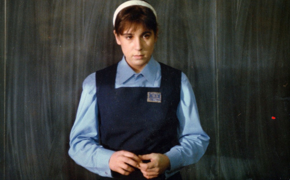 A young woman wears a school uniform.