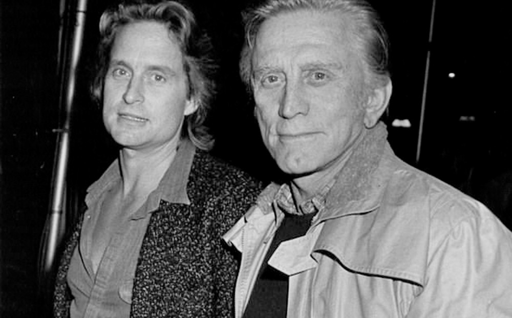 Black and white image of adult Michael Douglas and elderly Kirk Douglas looking at the camera.