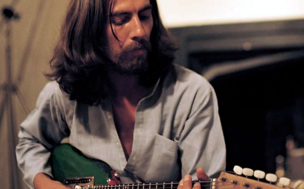 George Harrison plays guitar.