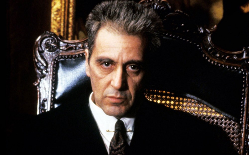 Actor Al Pacino looks directly forward, seated in an ornate chair.
