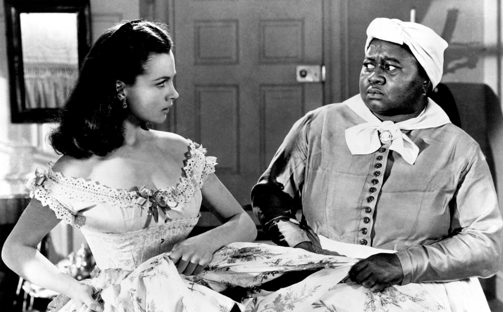 Actor Hattie McDaniel stands next to actor Vivien Leigh; they look at each other with displeasure.