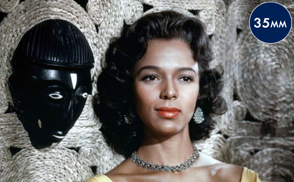 Actor Dorothy Dandridge stands next to a wall with an indigenous face mask.