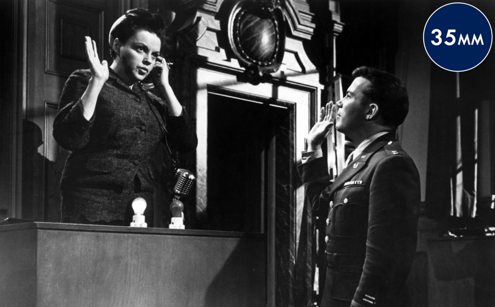 Actor Judy Garland takes an oath on the witness stand in a courtroom.