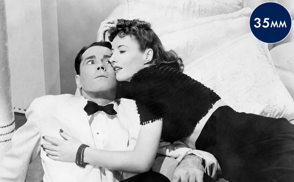 Actor Barbara Stanwyck cuddles with a scared-looking Henry Fonda.
