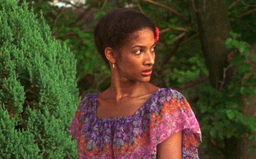 Actor Seret Scott looks over her shoulder while walking in a wooded area.