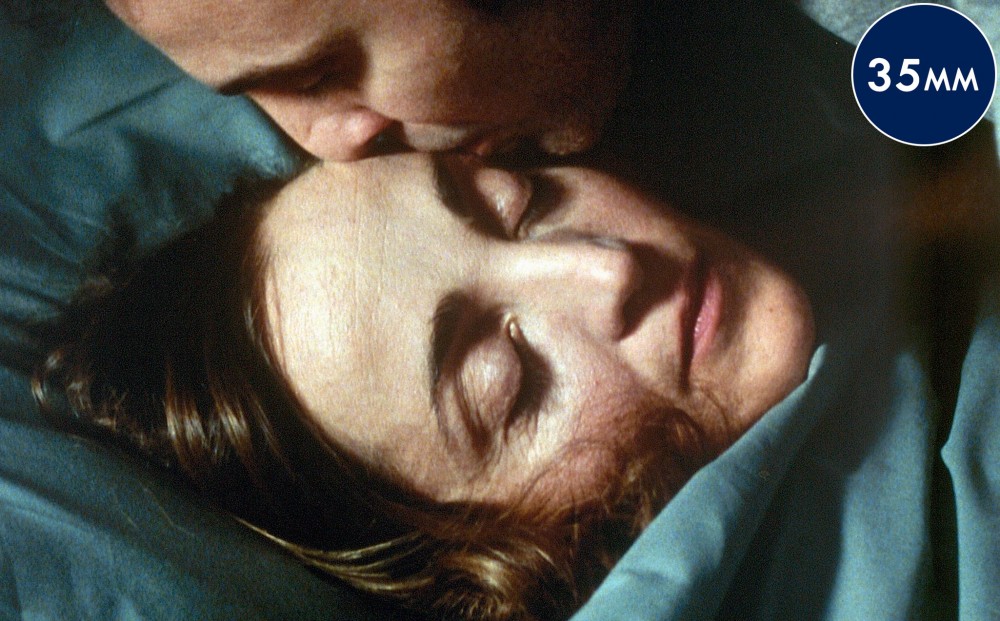 Close-up of actor Gilbert Melki kissing Dominique Blanc's forehead.
