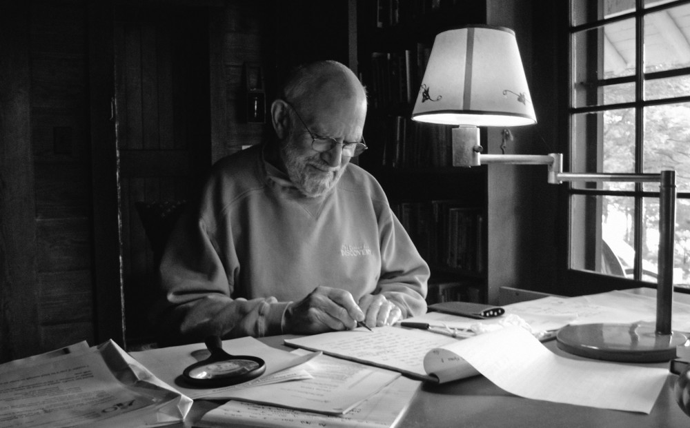 Oliver Sacks sits at his desk, writing.