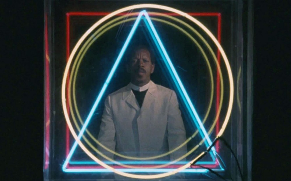 Ornette Coleman appears, surrounded by a neon, geometric-shaped sign.
