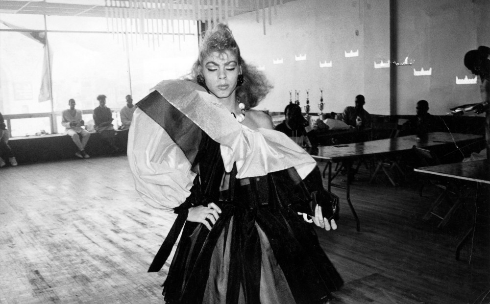 Venus Xtravaganza struts, wearing a dress with poofy sleeves.