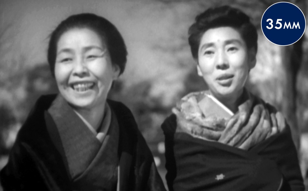Two women smile.