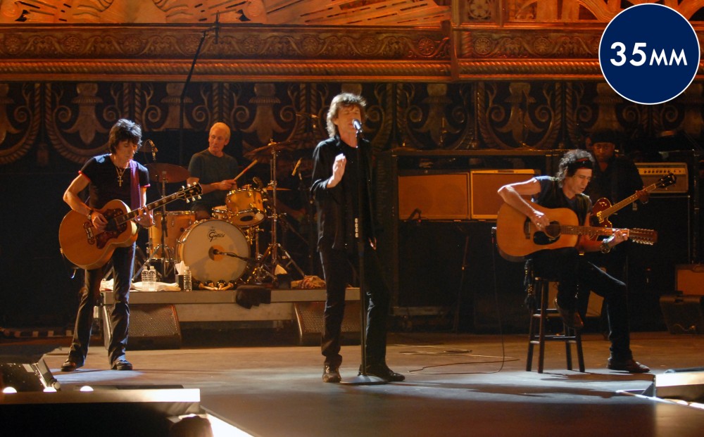 The Rolling Stones perform on stage - two guitarists, a bass player, a singer, and a drummer.