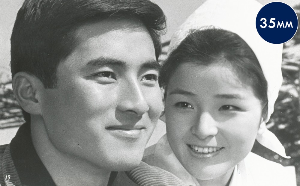 Close-up on the faces of a man and woman, both smiling