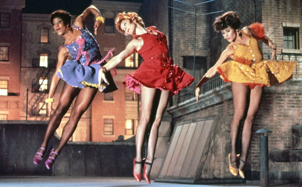 Actors/dancers Shirley MacLaine, Chita Rivera, and Paula Kelly mid-jump in a dance number.
