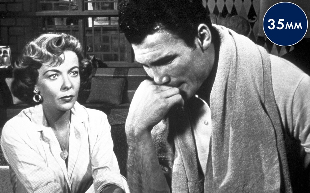Actor Ida Lupino looks intently at actor Jack Palance.
