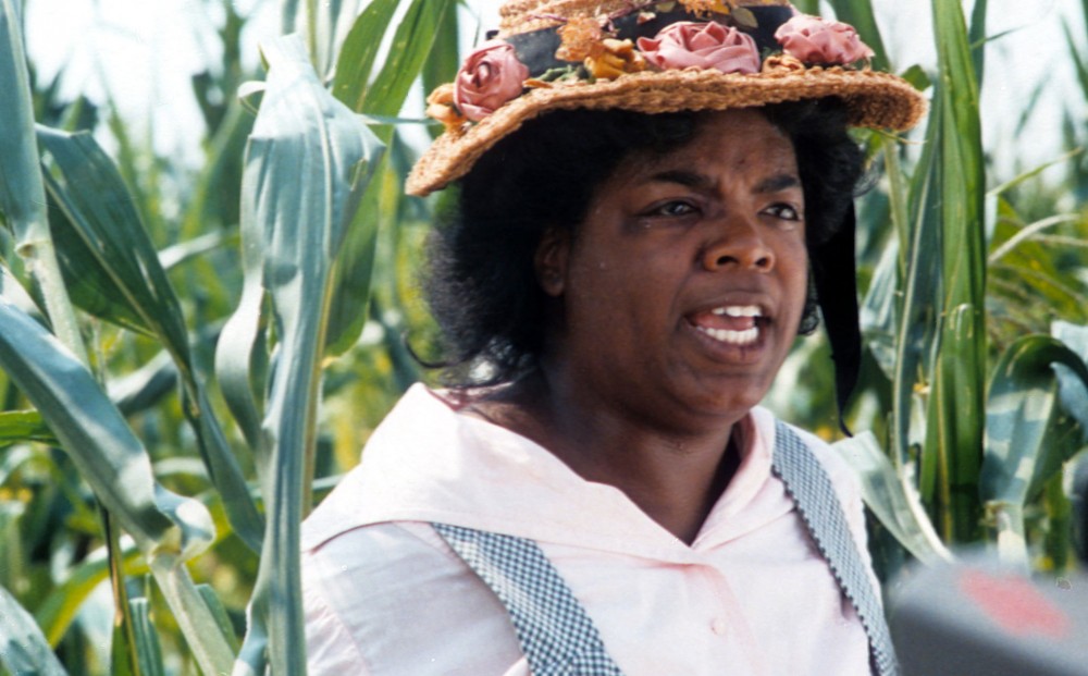 Oprah Winfrey stands in a corn field.