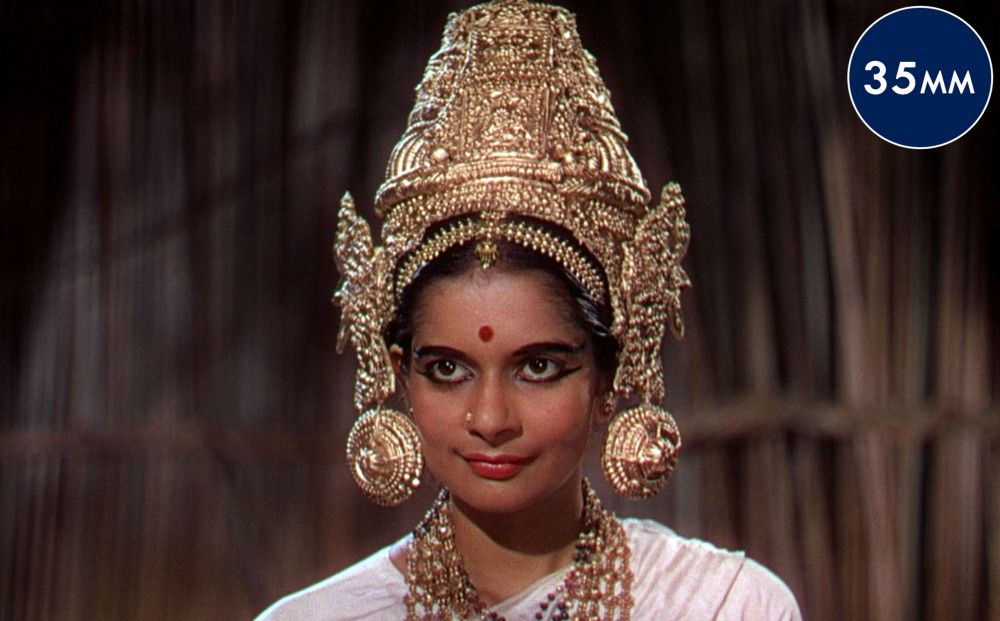 A woman wearing a gold ritual Indian crown.