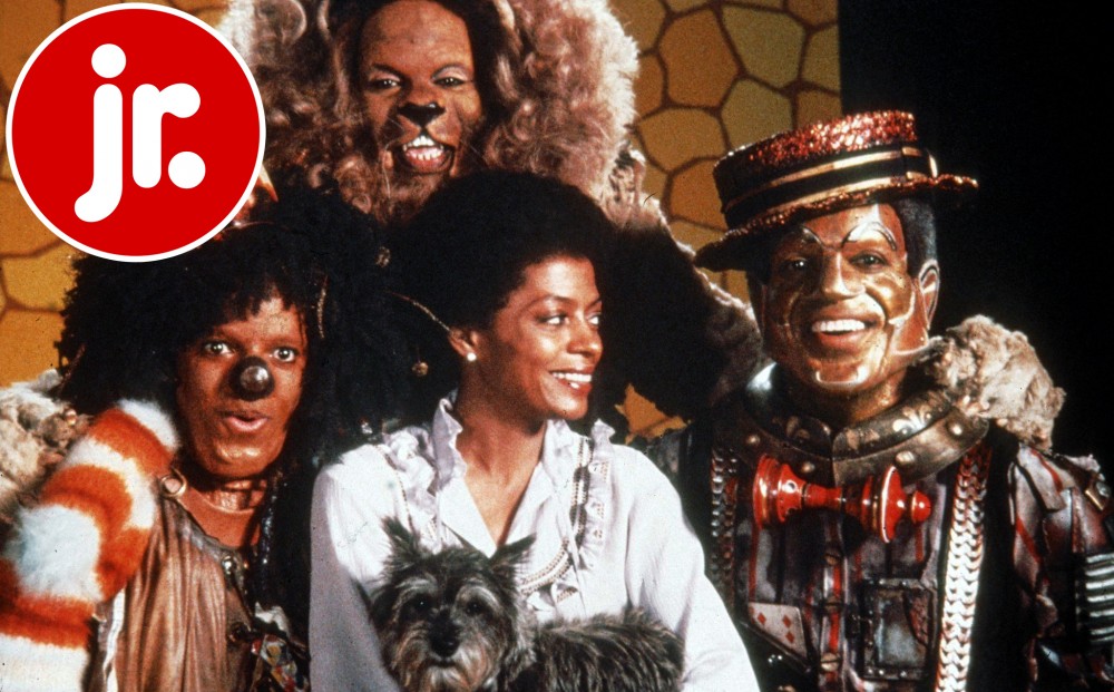 Diana Ross as Dorothy, holding her dog Toto. The Tin Man, the Cowardly Lion, and the Scarecrow characters surround her.