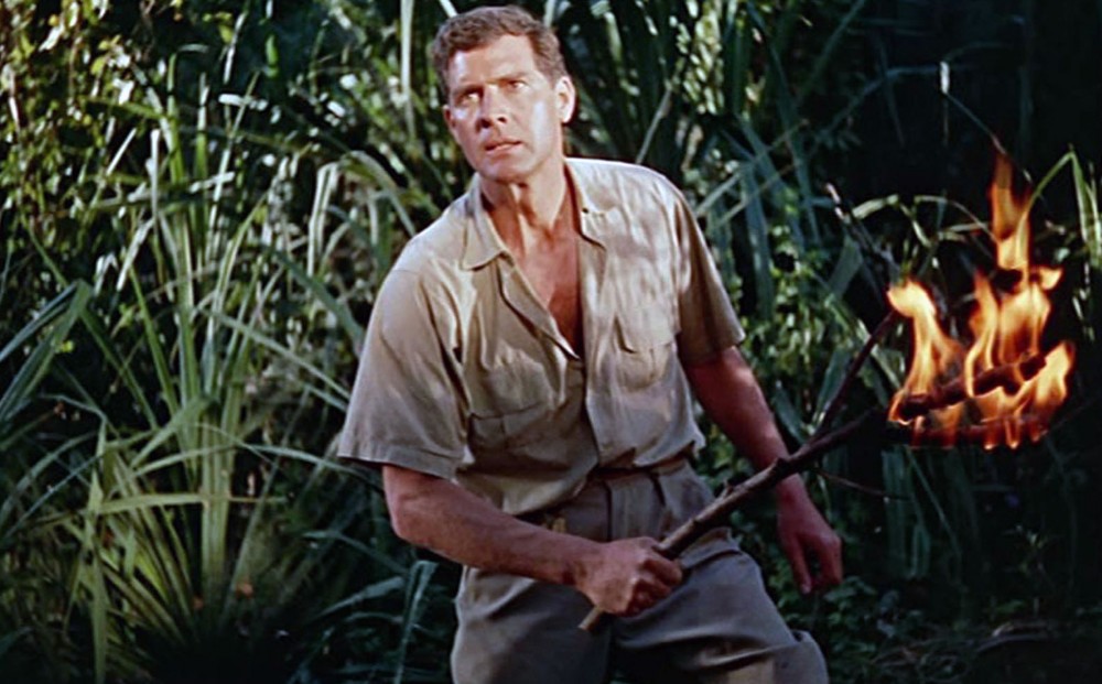 From THE TIGER OF ESCHNAPUR: Actor Paul Hubschmid stands in the jungle holding a torch.