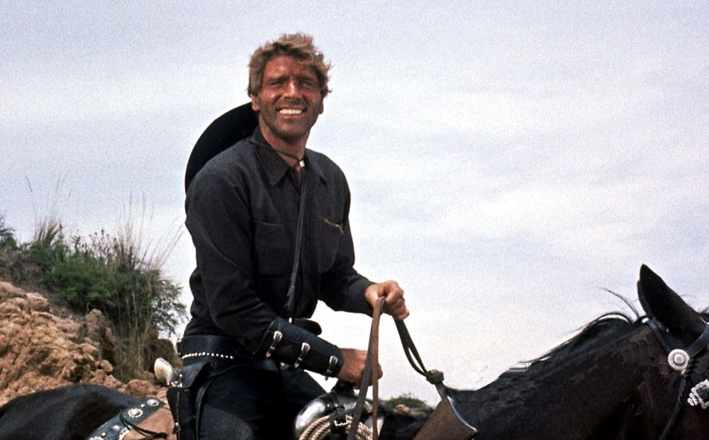 Actor Burt Lancaster rides a horse and greens.