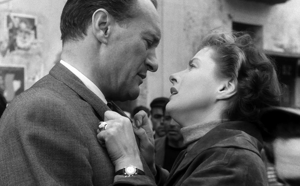 Actor Ingrid Bergman clings to George Sanders' suit jacket collar.