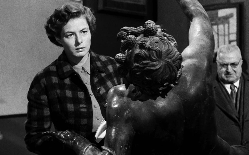 Actor Ingrid Bergman gazes at a statue.