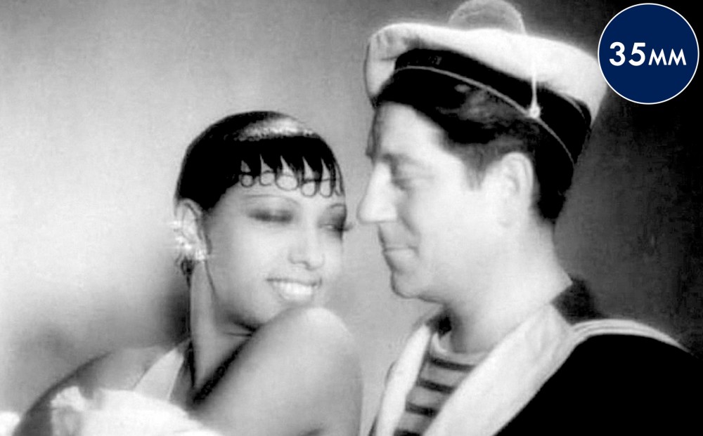 Actor Josephine Baker and a sailor smile at each other.